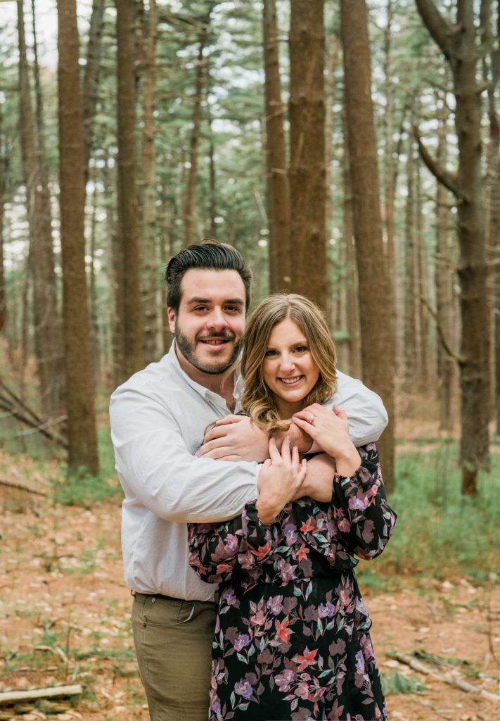 Couple hugging in nature during winter engagement session